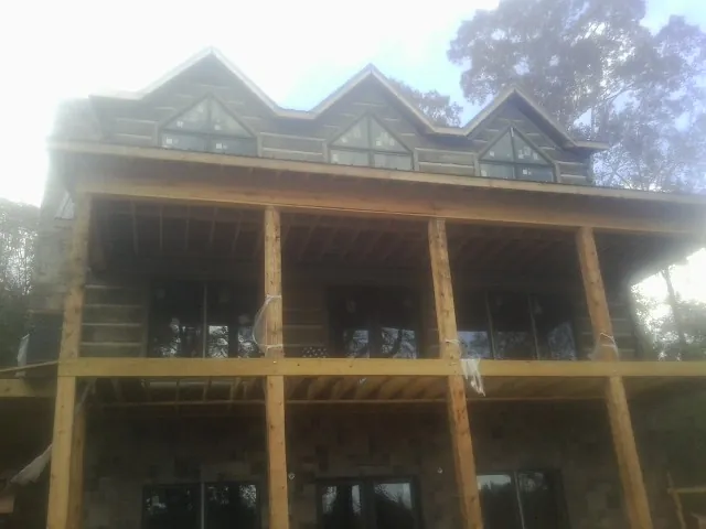 Dormers and porch framing on a large log home under construction — Roof Coating work by our crew in Zelienople